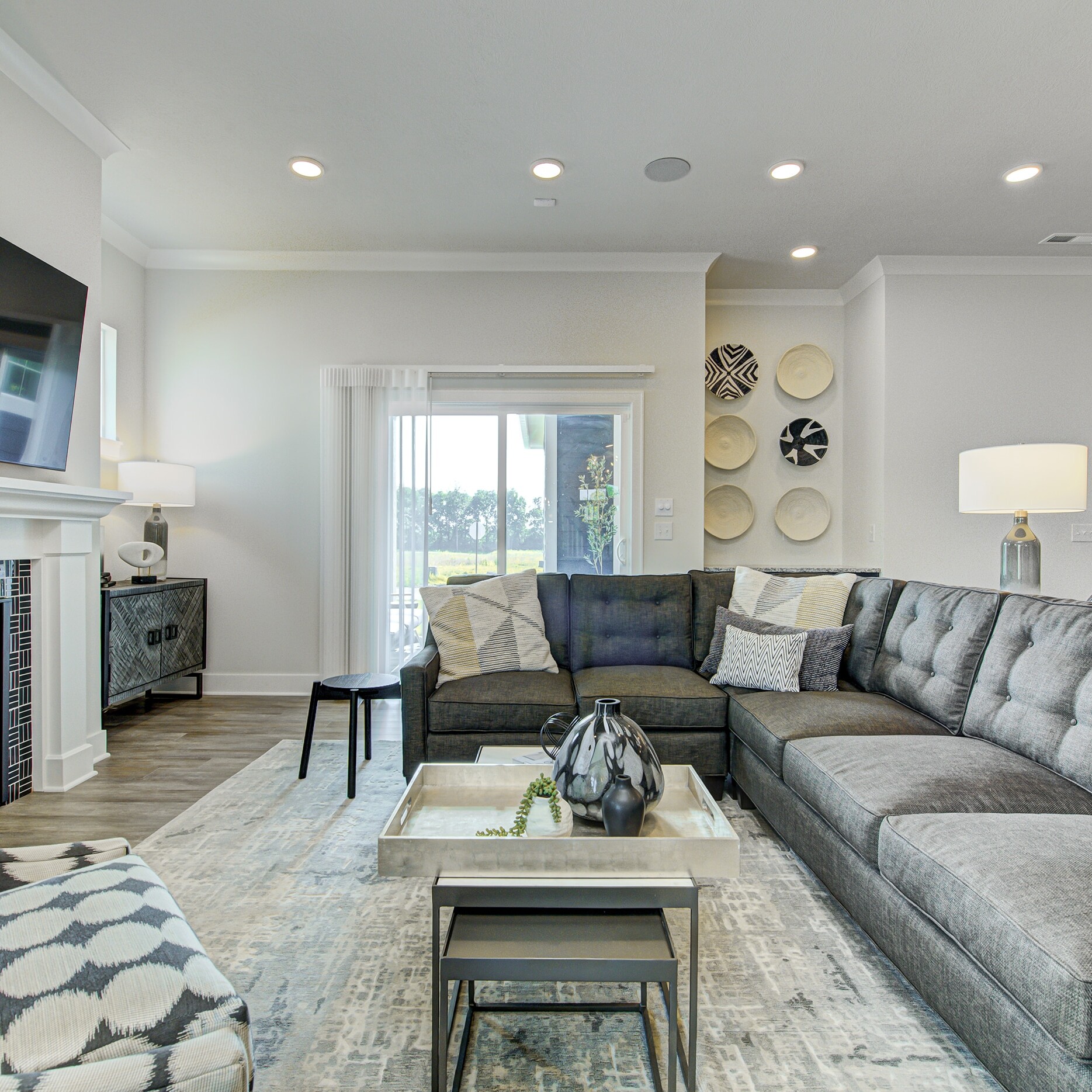 A living room with gray furniture and a fireplace.