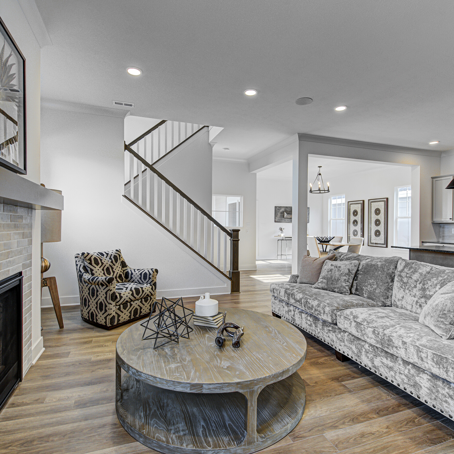 A living room with a fireplace and a staircase.
