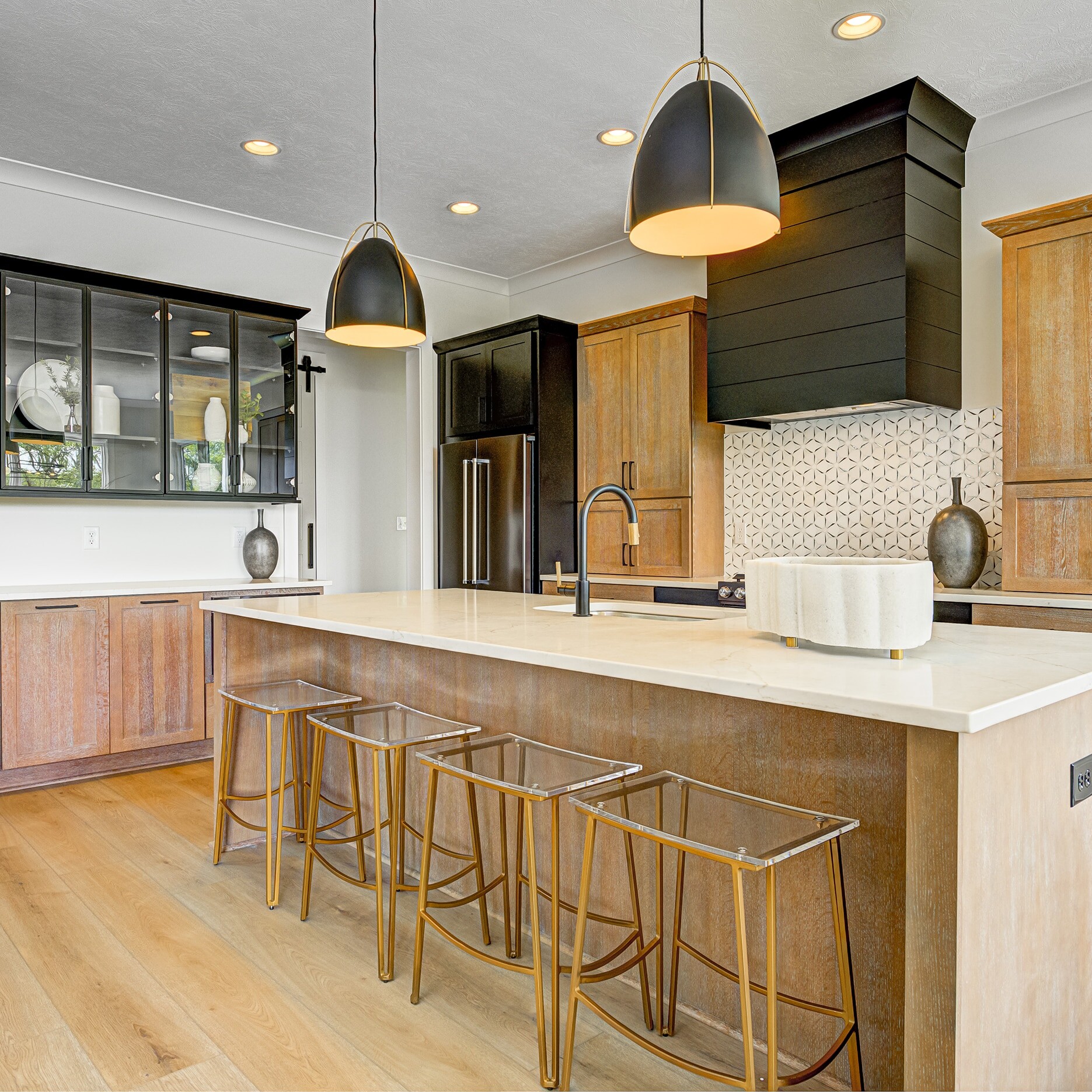 A kitchen with a center island and bar stools.