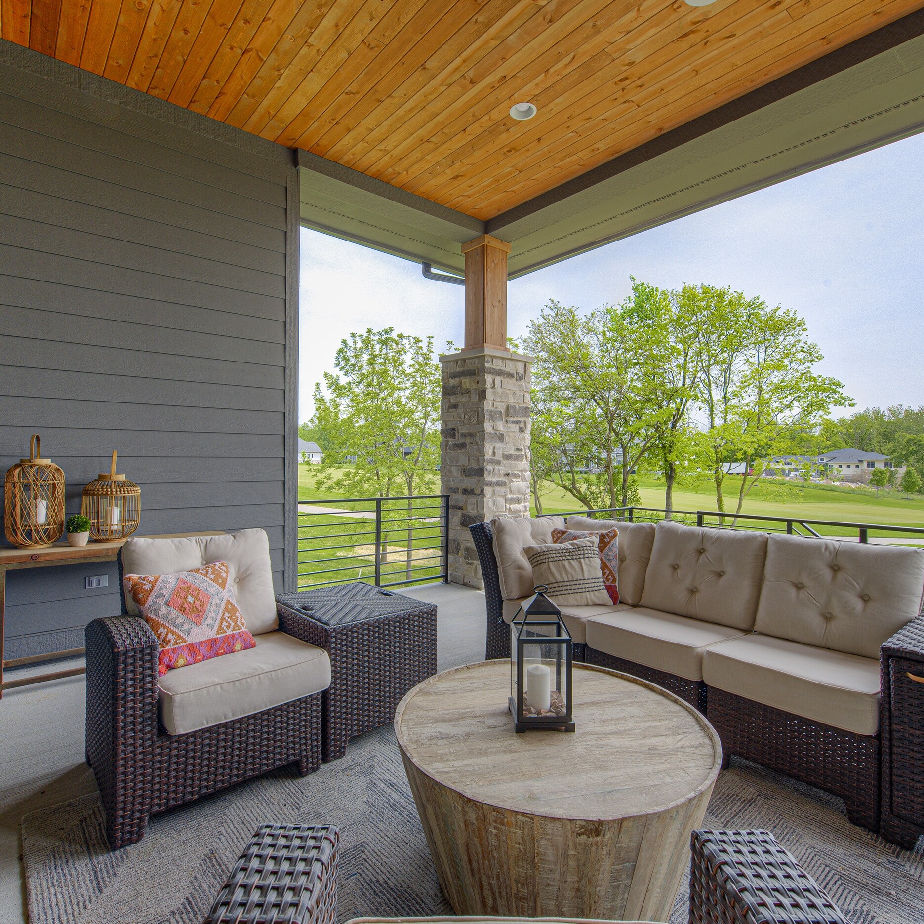 A porch with wicker furniture and a table.