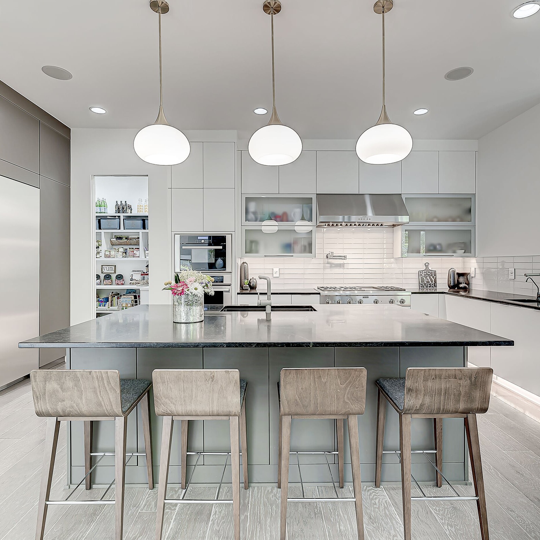 A modern kitchen with a center island and bar stools.