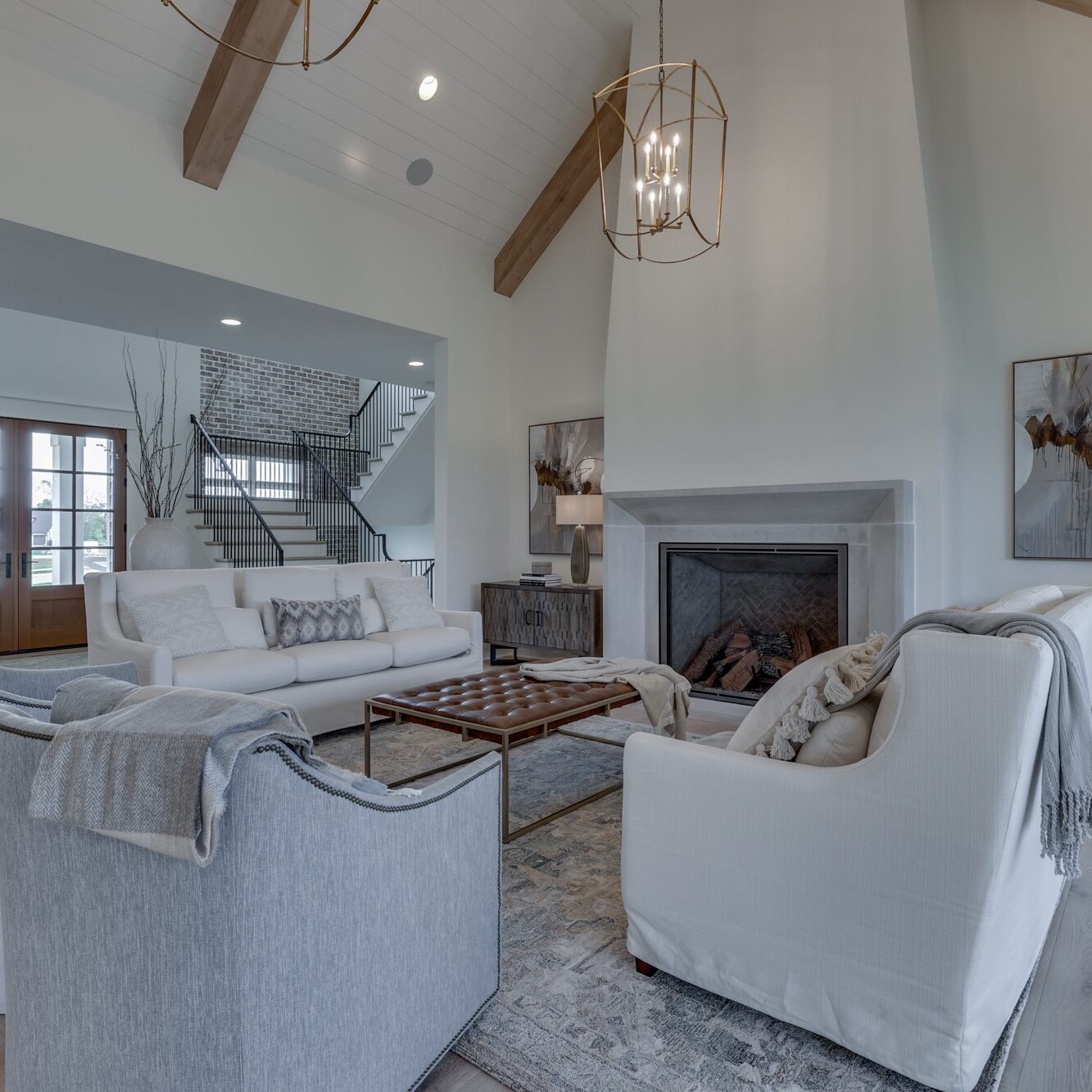 A living room with white furniture and a fireplace.