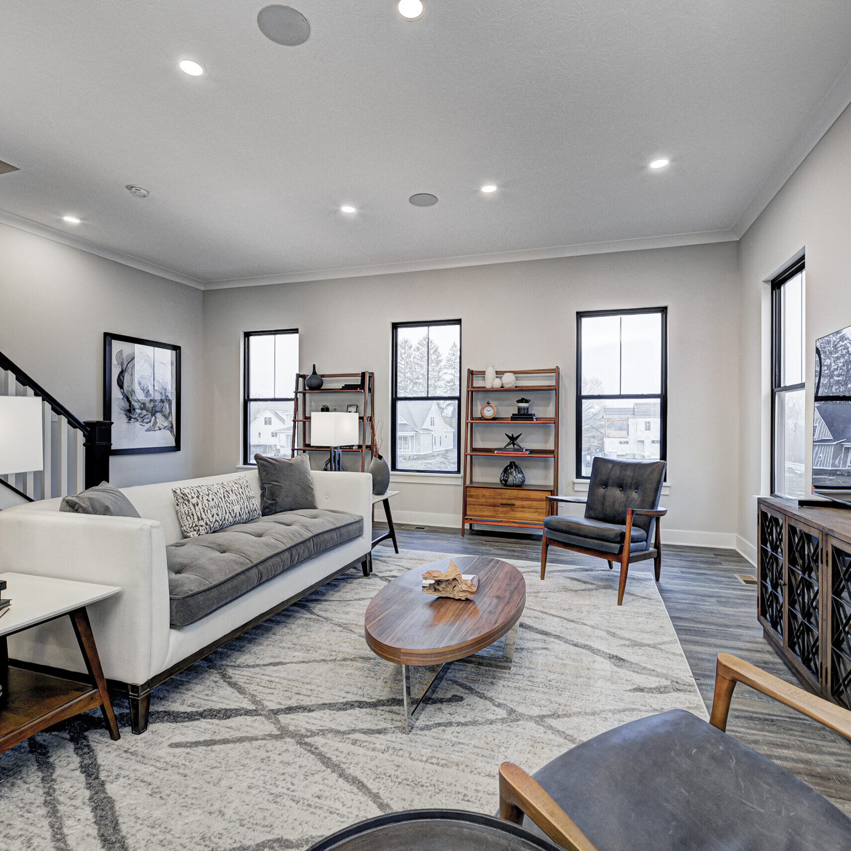 A cozy living room with comfortable couches and a stylish stairway, expertly crafted by a reputable custom home builder in Fishers Indiana.
