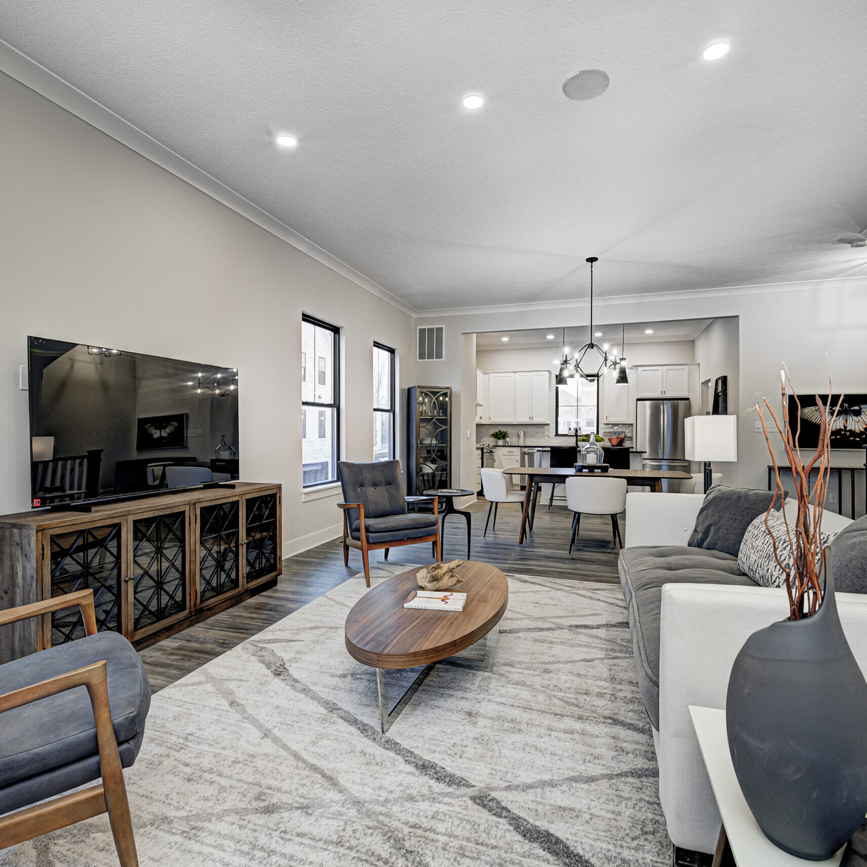 A living room adorned with beautiful hardwood floors and featuring a stylish TV, crafted by an exceptional Custom Home Builder in Carmel Indiana.