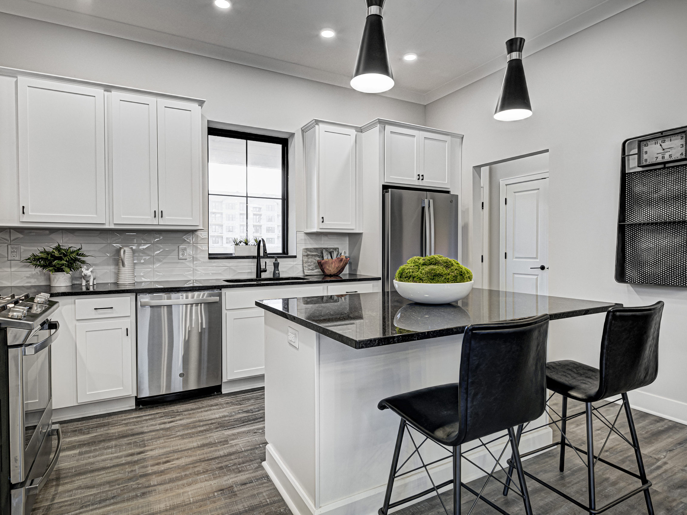 A custom kitchen with white cabinets and black counter tops.