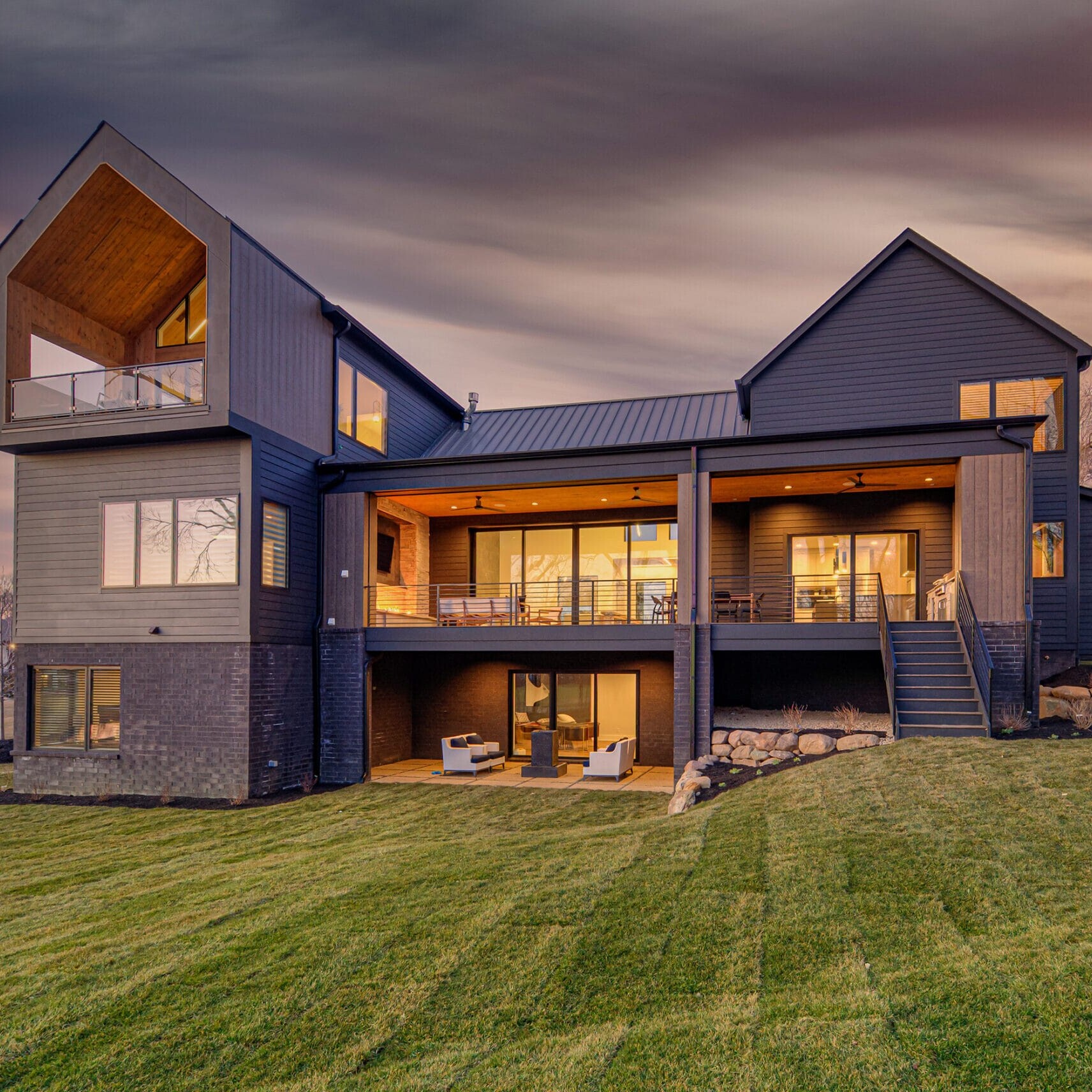 A modern home on a hillside at dusk.