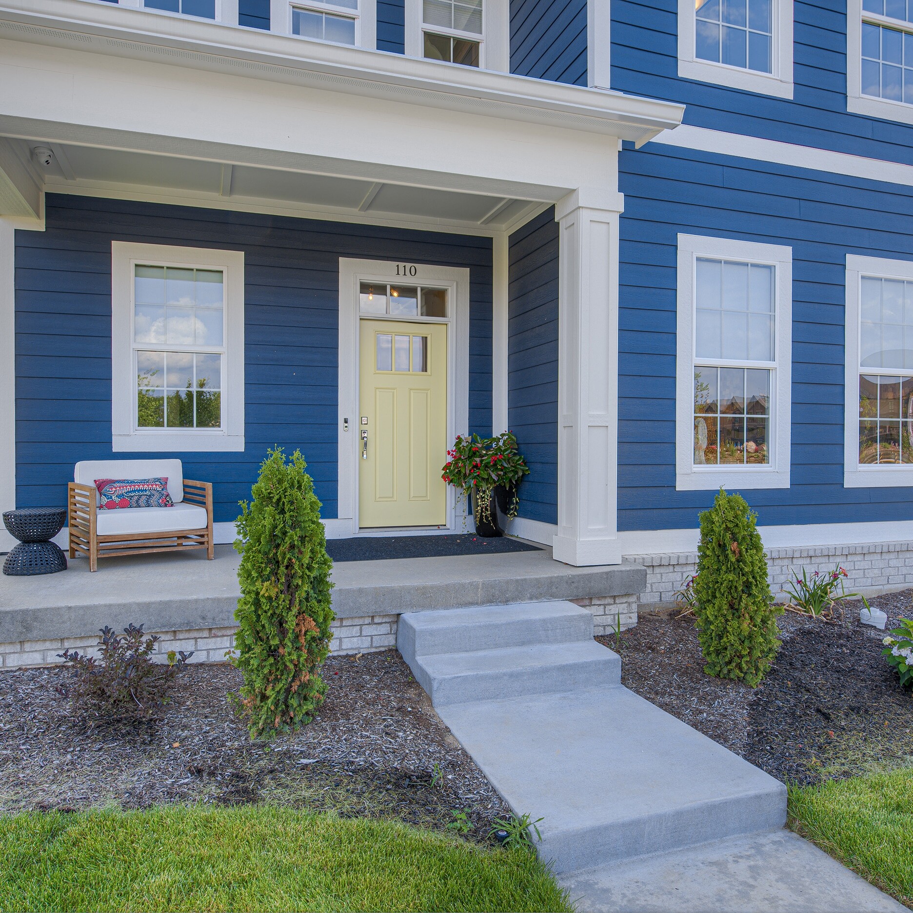 A blue house with a yellow door and steps.
