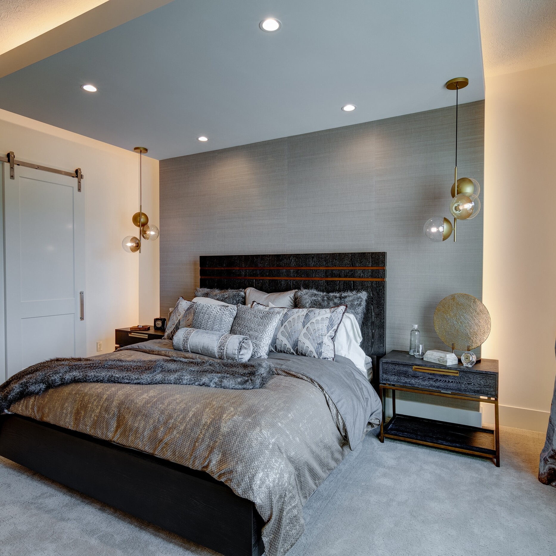 A bedroom with a large bed and a bedside table.