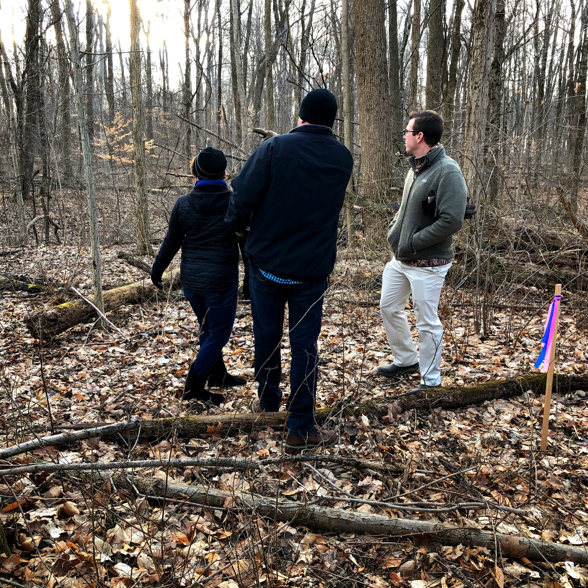 Three people standing in a wooded area near a custom home builder in Fishers, Indiana.