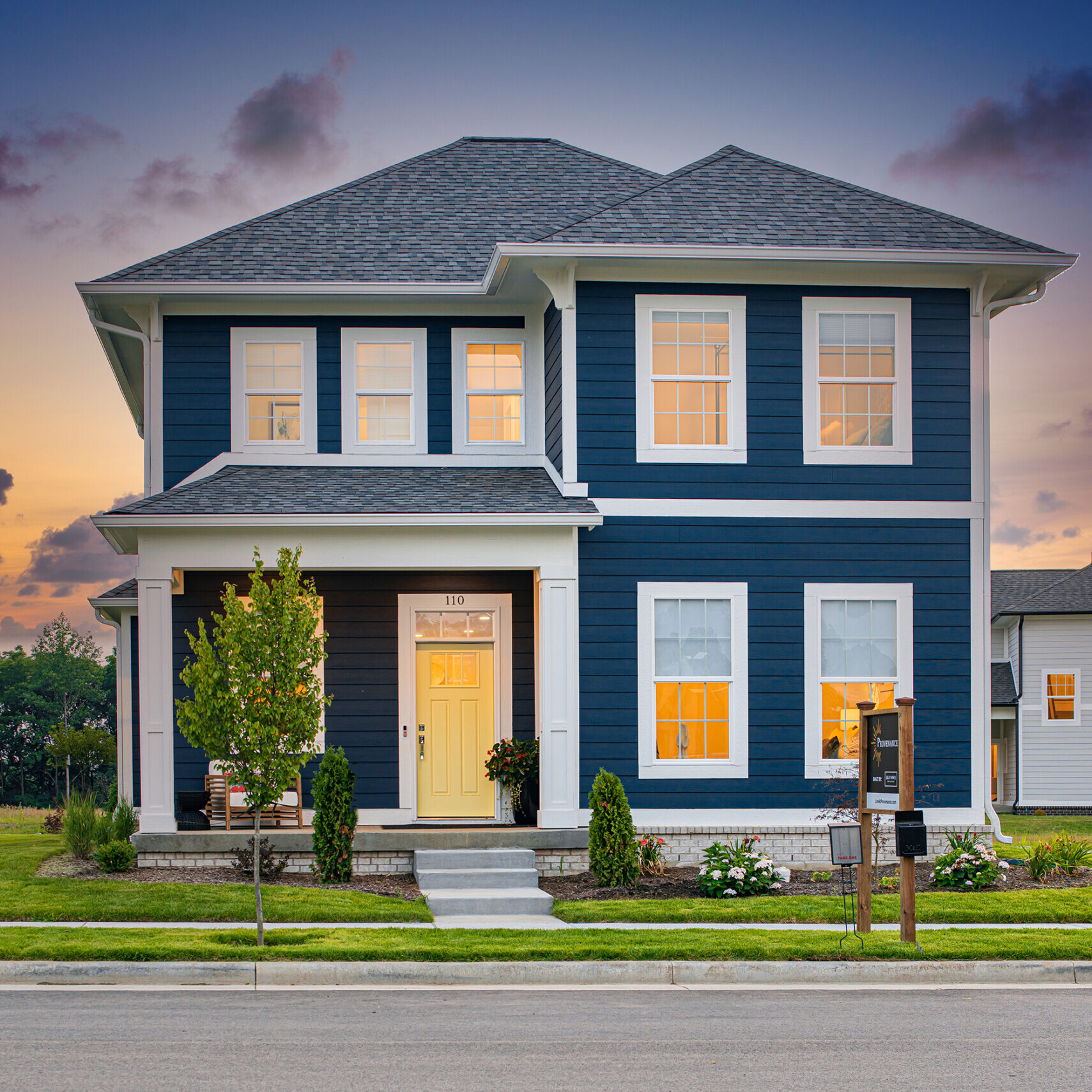 A blue and white custom home at dusk in Fishers, Indiana.