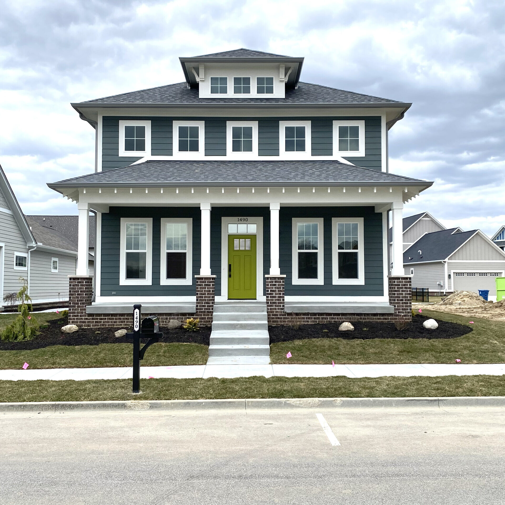 A beautiful custom home with a green door, located in Indianapolis, Indiana.