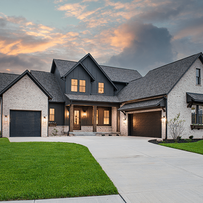 A home with a driveway and garage at dusk.