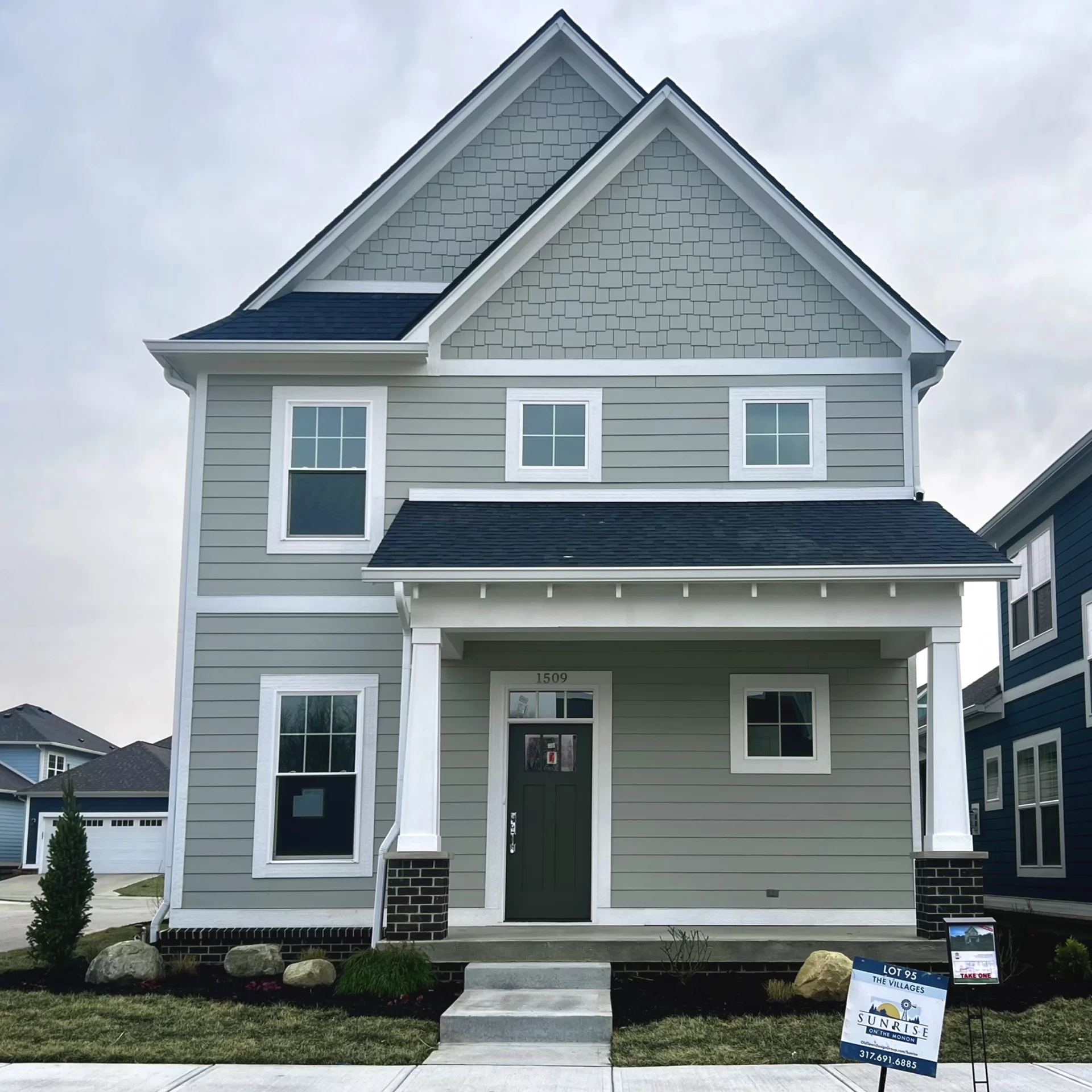 A two story Indianapolis custom home with gray siding and white trim.